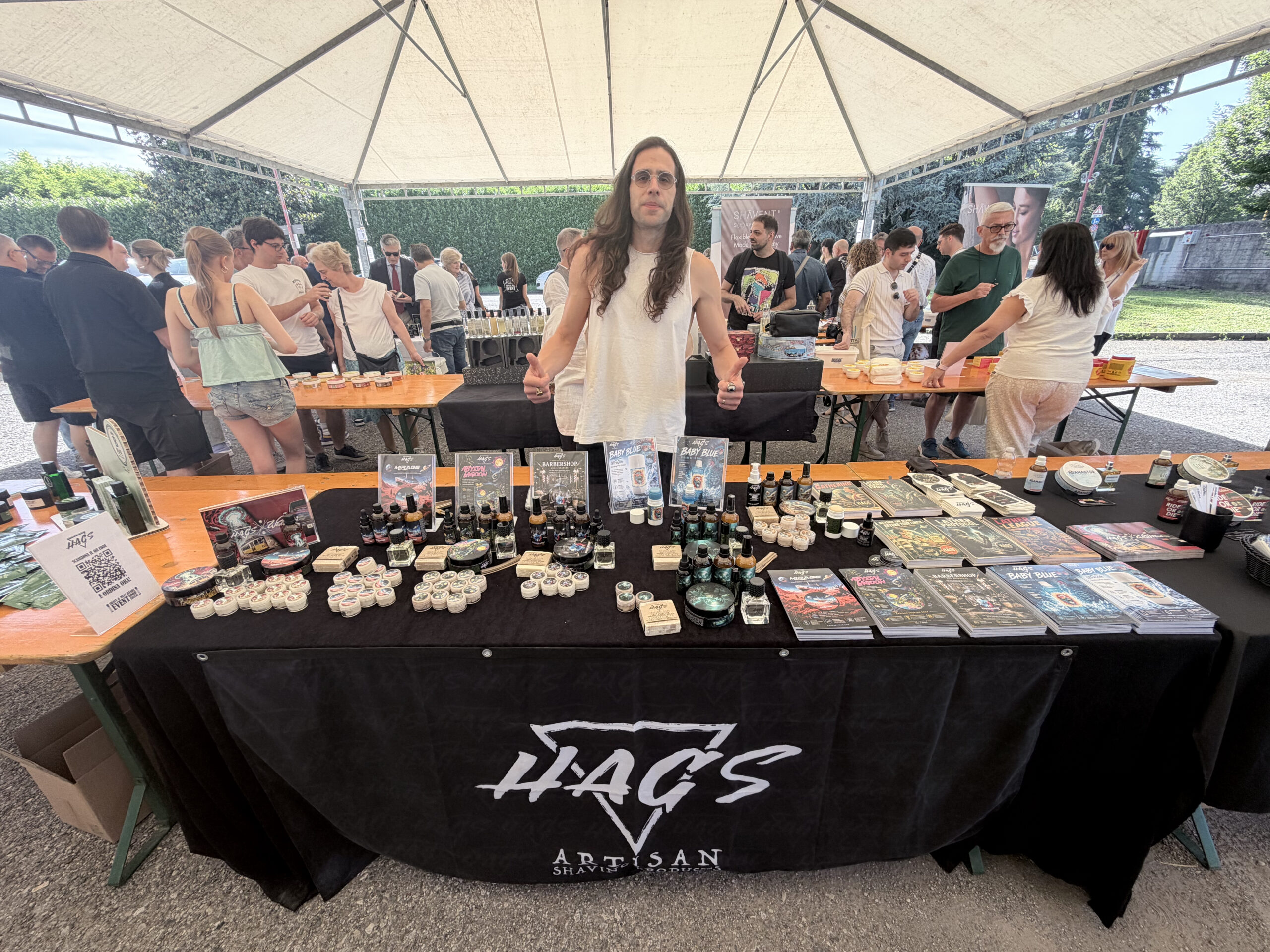 Το περίπτερο της HAGS Artisan Shaving Products σε εκδήλωση, με σαπούνια ξυρίσματος, προϊόντα περιποίησης και καλλιτεχνικά σχεδιασμένες συσκευασίες.